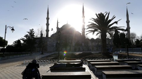 Varias personas descansan en unos bancos situados frente a la Mezquita Azul tras el atentado suicida perpetrado en el turístico distrito de Sultanahmet, en el centro de Estambul (Turquía). EFE/Sedat Suna