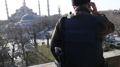 Un miembro de las grupos especiales de la Policía turca vigila desde un edificio cercano después de que se produjera una fuerte explosión en los alrededores de la Mezquita Azul en la que al menos diez personas han muerto y otras quince han 