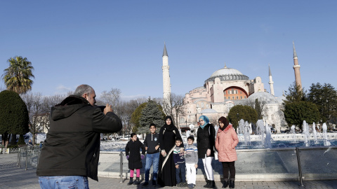 Una familia posa para una foto con Santa Sofía de fondo tras el atentado suicida perpetrado en el turístico distrito de Sultanahmet, en el centro de Estambul (Turquía). EFE/SEDAT SUNA