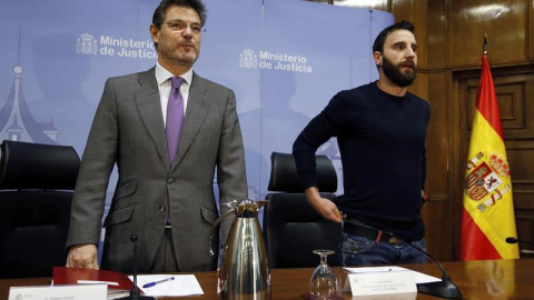 El ministro de Justicia, Rafael Catalá (i), acompañado por el actor y humorista Dani Rovira, durante la inauguración de una jornada en la que se analiza el endurecimiento de las penas en los casos de maltrato animal que recoge el nuevo Códi