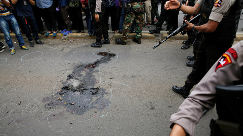 Policías indonesios, junto a la silueta de un cadáver, en el distrito financiero de Thamrin en Yakarta, tras el asalto de un grupo de hombres armados en el centro de la capital indonesia. Los terroristas del Estado Islámico habían amenazado