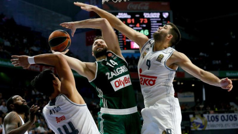 El pívot del Zalgiris Ian Vougioukas, entre Felipe Reyes y Ayón. EFE/JuanJo Martín