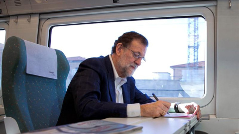 Fotografía facilitada por el PP del presidente del Partido Popular y presidente en funciones del Gobierno, Mariano Rajoy, tomando notas en el tren en el que viaja hacia Zamora,donde participa en un acto del Partido Popular./ EFE