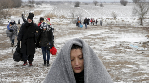 Refugiados sirios que huyen de la guerra en su país llegan por terrenos helados a la frontera de Macedonia. - REUTERS