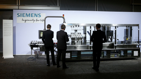 Varias personas en un stand de Siemens expuesto en la junta general de accionistas del gigante alemán, la pasada semana. REUTERS/Michael Dalder