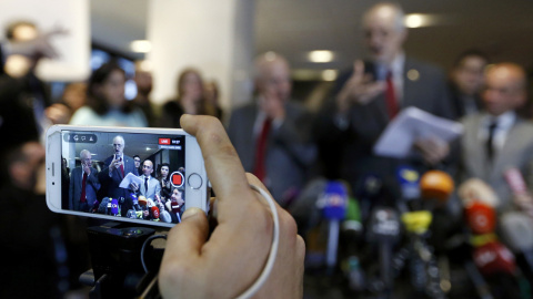 Un periodista graba en su teléfono móvil la comparecencia del embajador de Siria en la ONU, Bashar al Jaafari, por las conversaciones de paz de Ginebra. REUTERS/Denis Balibouse