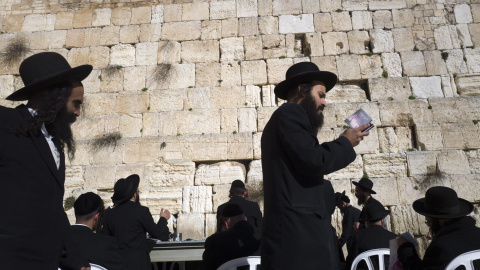 Judíos ultra-ortodoxos caminan en círculos alrededor de los demás, mientras que rezan ante el Muro de las Lamentaciones, el lugar más sagrado del judaísmo, en la Ciudad Vieja de Jerusalén. EFE / EPA / JIM HOLLANDER