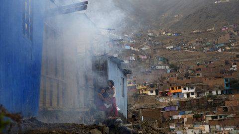 Una familia espera a que los trabajadores sanitarios terminen de fumigar su casa, durante la campaña contra el virus del Zika en una barriada de Lima (Perú). REUTERS/Mariana Bazo