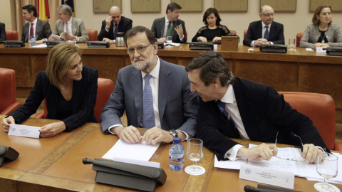 El presidente del Gobierno en funciones, Mariano Rajoy, junto a la secretaria general del PP, María Dolores de Cospedal, y el portavoz del partido en el Congreso, Rafael Hernando, durante la reunión que ha mantenido hoy con los diputados de