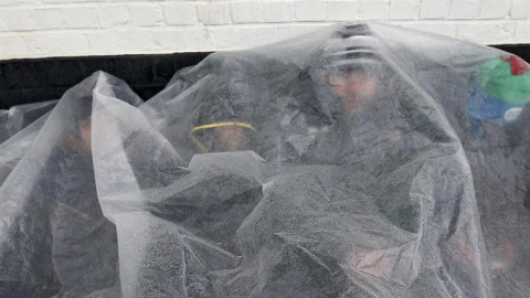 Refugiados intentan calentarse en el puerto de Zeebrugge, en Bélgica, donde pretenden embarcar rumbo a Reino Unido. / EFE