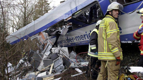 Un miembro de los equipos de rescate junto a los trenes accidentados. / EFE