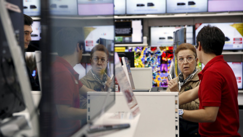 Un empleado de una cadena de productos de electrónica e infromática atiende a una clienta. REUTERS