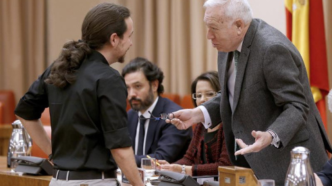 El ministro de Exteriores en funciones, José Manuel García-Margallo, conversa con el líder de Podemos, Pablo Iglesias. - EFE