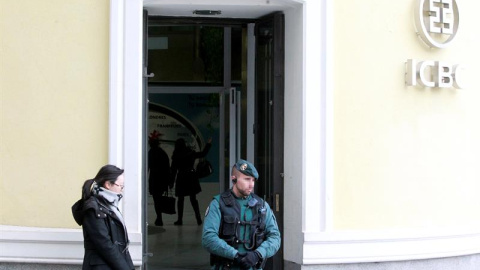 Un agente de la Guardia Civil controla ayer por la tarde la entrada a la sede del banco chino ICBC, en el centro de Madrid. /EFE