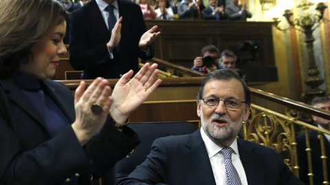 El presidente del Gobierno en funciones y líder del PP, Mariano Rajoy (d), ha sido recibido con un estruendoso aplauso por los diputados de su grupo al entrar al hemiciclo del Congreso, donde inaugura la segunda jornada del debate de invest