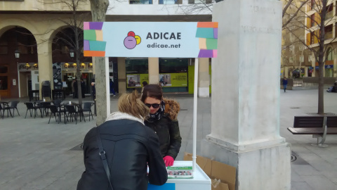 La organización de consumidores y usuarios Adicae recoge firmas para denunciar abusos con las comisiones ante una oficina de Bankia en Zaragoza.