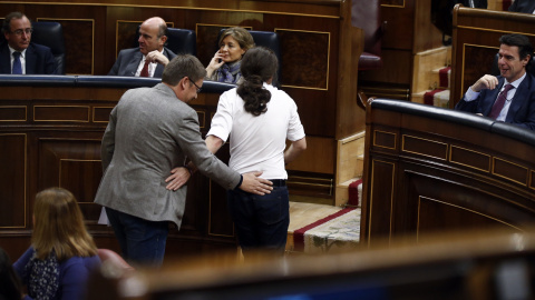 El líder de Podemos, Pablo Iglesias, y el de En Comú Podemo, Xavier Domenech, se saludan al volver a sus asientos.- REUTERS/Andrea Comas