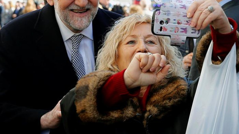 Mariano Rajoy se hace un 'selfie' con una mujer a la salida este miércoles del Congreso. - EFE