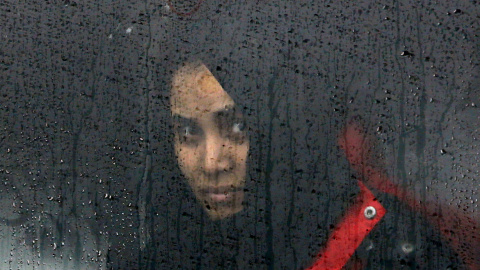 Una mujer mira por la ventana de un tren mientras espera poder abandonar el campo de Slavonski Brod. - REUTERS