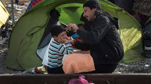 Unos refugiados esperan al norte de Grecia entrar en Macedonia.- EFE