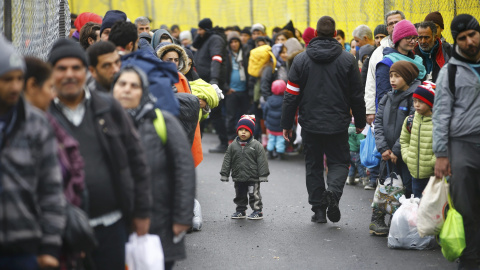 Decenas de personas esperan, cargados con sus pocos enseres, a poder cruzar la frontera de Eslovenia para llegar a Spielfeld, Austria.- REUTERS