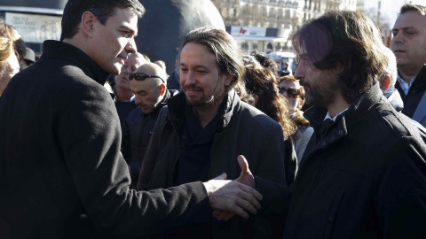 El secretario general del PSOE, Pedro Sánchez (i), saluda al responsable de Relaciones con la Sociedad Civil de Podemos, Rafael Mayoral, en presencia del líder de la formación, Pablo Iglesias, durante el homenaje.- EFE