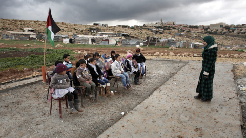 Una maestra palestina durante una clase a niños en la comunidad de Abu Nawar cerca del asentamiento judío de Maale Adumim, en la ciudad cisjordana de Al-Azariya, al este de Jerusalén. AHMAD GHARABLI / AFP