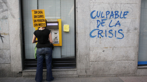 Una participante en una manifestación contra la austeridad, en un cajero automático en Madrid. REUTERS