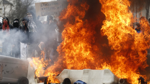 Manifestantes tras una barricada de contenedores ardiendo durante una protesta contra la reforma laboral de Frnacia en Nantes.-  REUTERS / Stephane Mahe