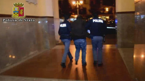 Imagen de un video de la Policía italiana de dos agentes con el argelino Djamal Eddin Ouali, arrestado por su supuesta relación con los terroristas yihadistas de Bruselas. EFE