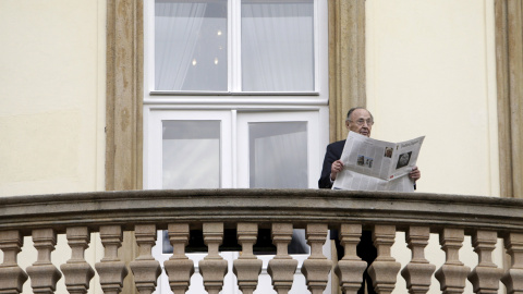 Former West German foreign minister Hans-Dietrich Genscher poses with newspapers on the balcony of the German embassy in Prague to mark the 25th anniversary of the East German exodus, in Prague in this file picture taken September 30, 2014.