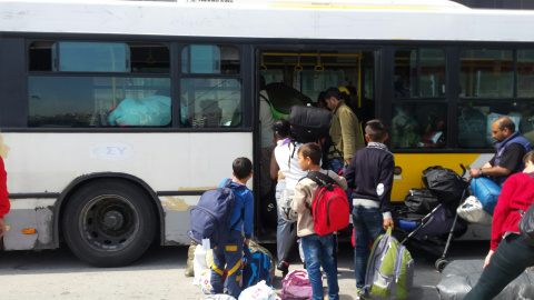 Uno de los autobuses que desaloja refugiados del puerto ateniense.