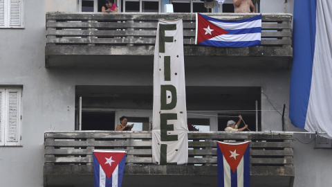 Banderas y un cartel con el nombre Fidel Castro cuelgan desde la fachada de un edificio, este jueves en la La Habana (Cuba). REUTERS