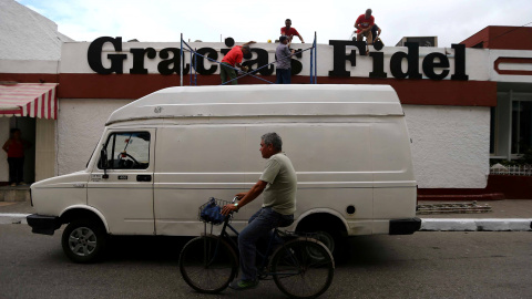 Unos trabajadores cuelgan un mensaje que dice 'Gracias Fidel' en la pared de un establecimiento en Santa Clara. REUTERS