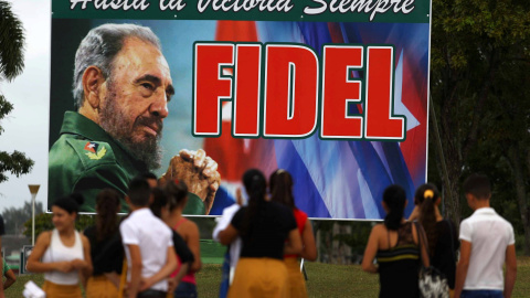 La gente espera frente a una valla publicitaria de Fidel Castro con el mensaje "hasta la victoria, siempre" en Santa Clara. REUTERS