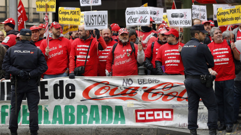 Trabajadores de Coca-Cola durante la concentración que han protagonizado ante la sede nacional del PP, en la que han estado acompañados por el líder de Podemos, Pablo Iglesias. EFE/Chema Moya