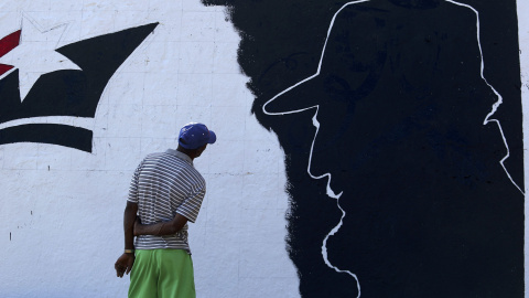 Un hombre mira un mural de Fidel Castro en las afueras de Santiago de Cuba. REUTERS