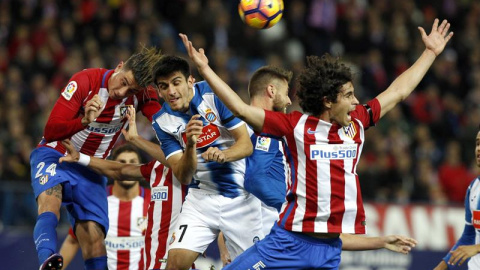 El jugador del Espanyol Gerard Moreno salta a por un balón entre Giménez y Tiago Cardoso, del Atlético. - EFE