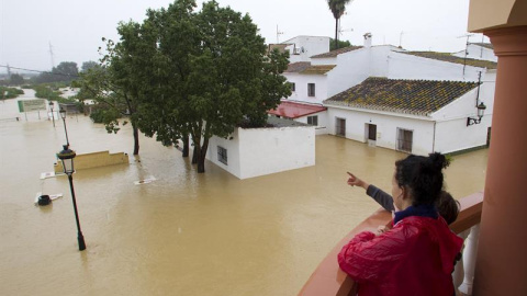 Varias personas observan el estado de sus casas inundadas en la barriada Doña Ana de la localidad de Cártama.- Daniel Pérez (EFE)