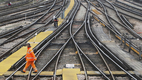 Un trabajador atraviesa las vías de la estación ferroviaria de Clapham Junction, en Londres. REUTERS/Luke MacGregor