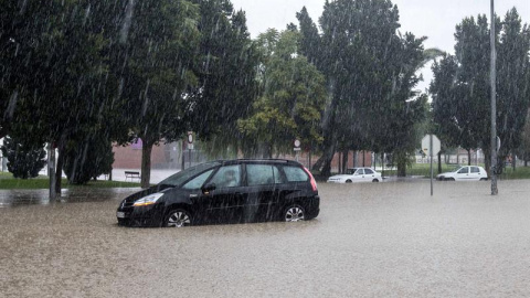 Un vehículo en medio de la intensa lluvia caída en la pedanía murciana de la Alberca (Murcia). EFE/Marcial Guillén