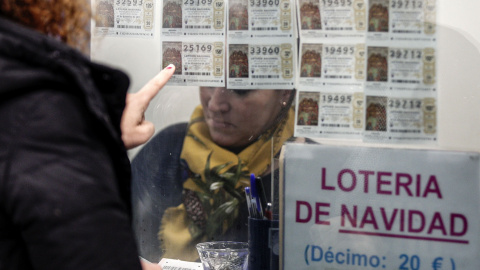 Una mujer escoge un décimo en una administración de Lotería en Valencia. EFE/Manuel Bruque