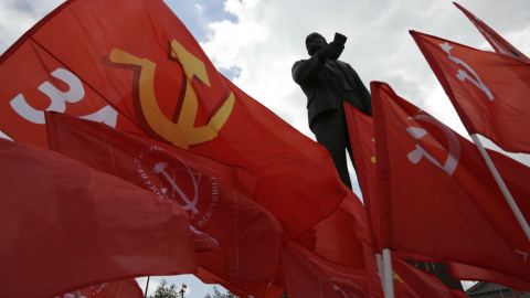 Miembros del Partido Comunista ondean sus banderas junto a una estatua de Vladimir Lenin en Simferopol, capital de Crimea. - AFP