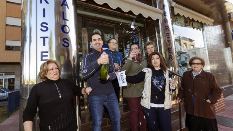 La vendedora de un quinto premio de la loteria de navidad, el número 22259, Carolina Abellán (2d), junto a su madre, dueña del la floristería y ferretería, Mari Carmen Espinosa (i), y su marido, Pedro Francisco Navarro (2i), celebran la ven