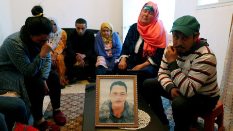 La familia de Anis Amri junto a una foto del presunto terrorista de Berlín.- EFE/Mohamed Messara