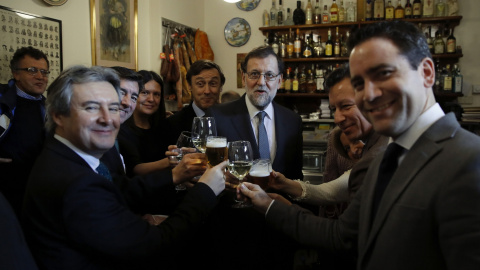 El presidente del Gobierno y del del Partido Popular, Mariano Rajoy,  acompañado de varios diputados de su formación en un bar proximo al Congreso de los Diputados tras la reunión que el grupo parlamentario popular ha celebrado en el cámara