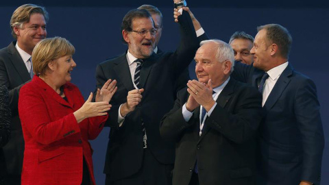 El presidente del Consejo Europeo, Donald Tusk (dcha.), levanta el brazo de Rajoy, junto al presidente el PPE, Joseph Daul (2dcha.), y Angela Merkel. EFE