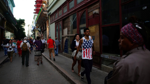 Un hombre cubano camina por las calles de La Habana con una camiseta  con la bandera estadounidense. / REUTERS