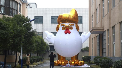 Un hombre hace una foto a una gallina gigante que representa a Donald Trump en una fábrica en Jianxing, en la provincia de Zheijiang (China). - EFE