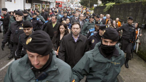 Concejales de Ponteareas salen escoltados del pleno por la policía tras una protesta de los preferentistas. / EFE